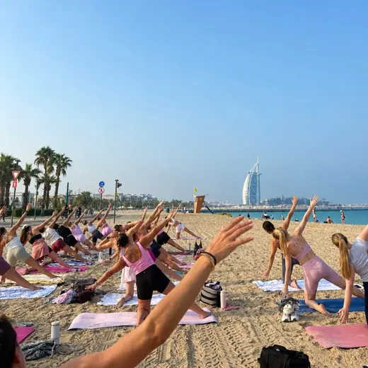 A Pilates class on the sand in Dubai with the Burj Al Arab behind