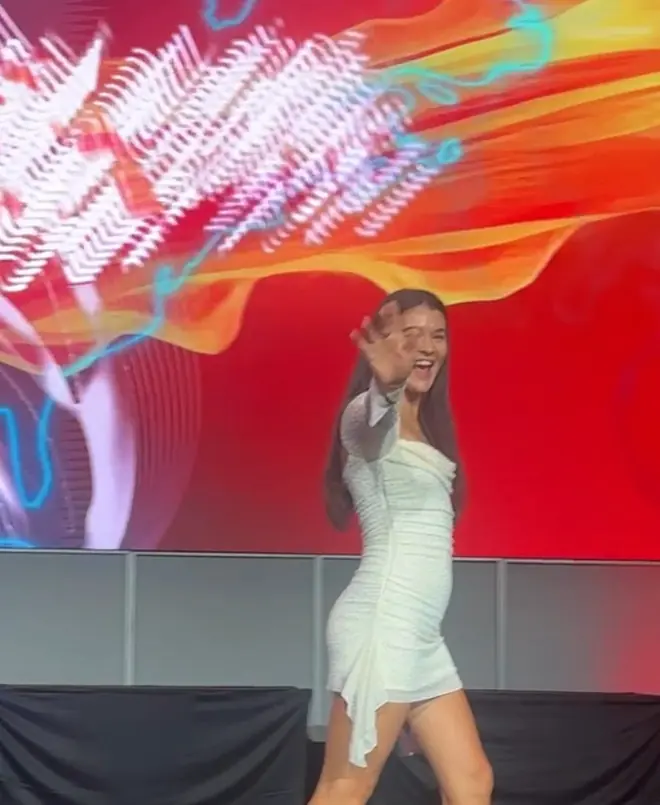 Renaé walking across a stage at a business event